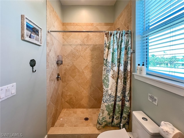 bathroom featuring walk in shower and toilet