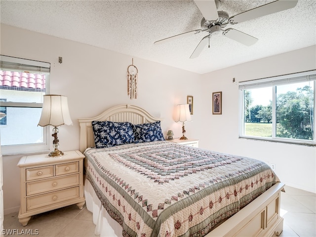 tiled bedroom featuring ceiling fan and a textured ceiling