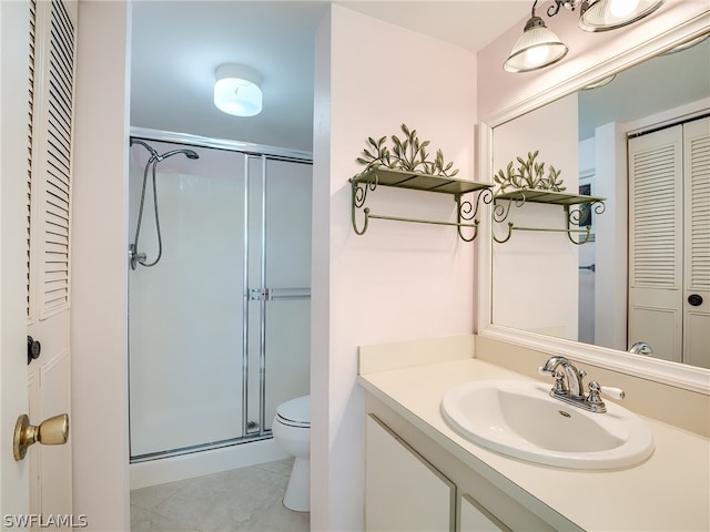 bathroom featuring a shower with door, toilet, oversized vanity, and tile flooring