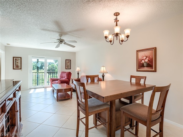 dining area with ceiling fan with notable chandelier, a textured ceiling, and light tile floors