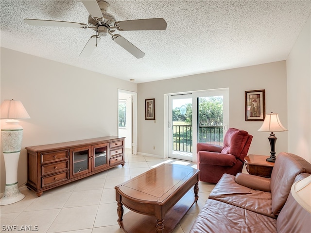 living room with a textured ceiling, ceiling fan, and light tile floors