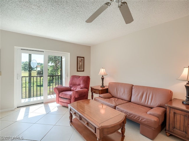 living room with a textured ceiling, ceiling fan, and light tile floors