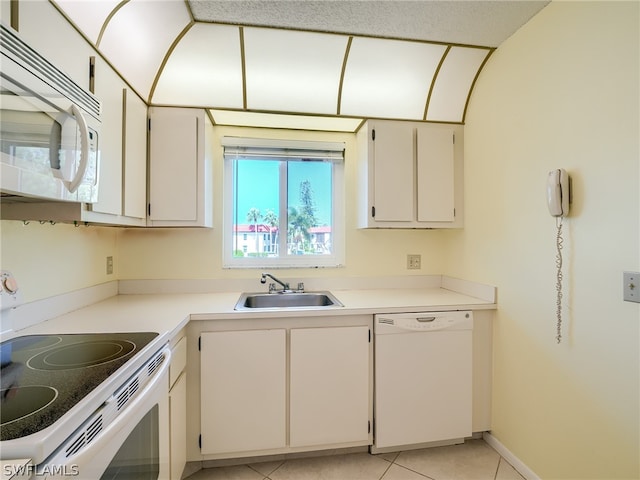 kitchen with light tile flooring, white appliances, and sink