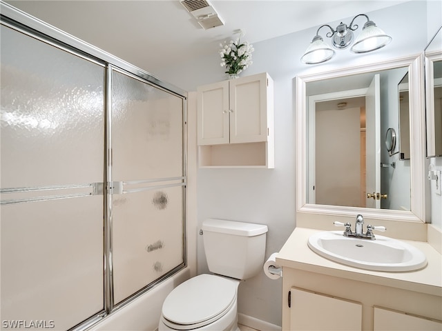 full bathroom featuring toilet, shower / bath combination with glass door, and vanity