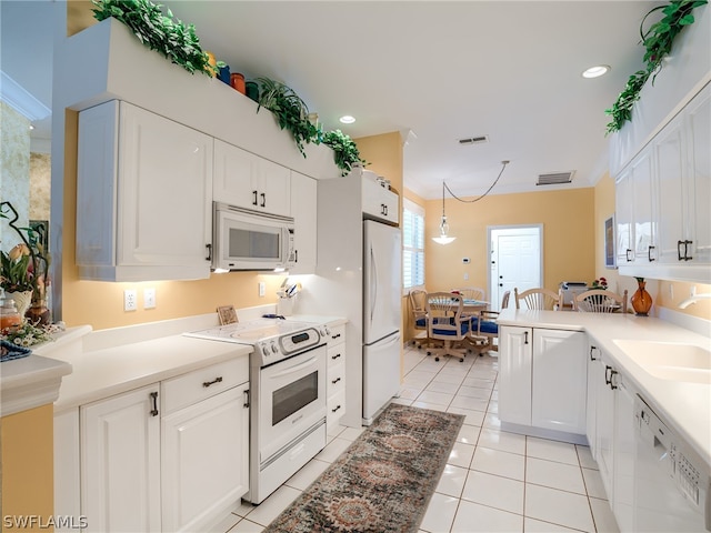 kitchen with decorative light fixtures, white cabinets, white appliances, light tile flooring, and sink