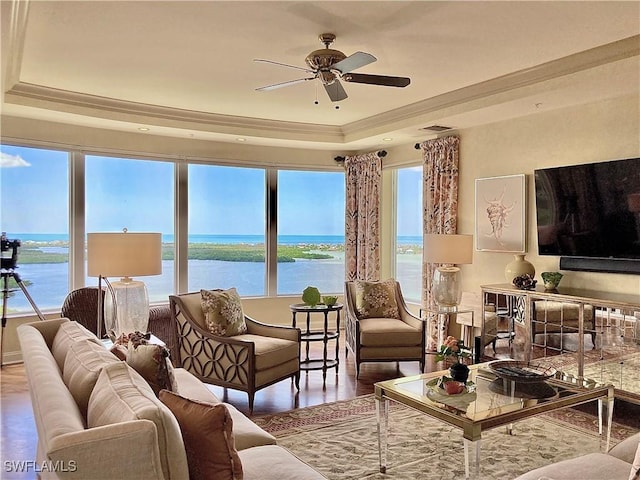 living room with hardwood / wood-style floors, ceiling fan, crown molding, and a tray ceiling