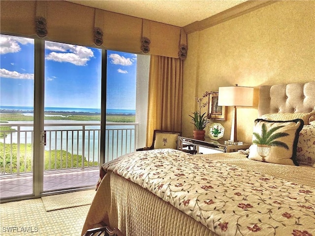 bedroom featuring a water view and access to outside