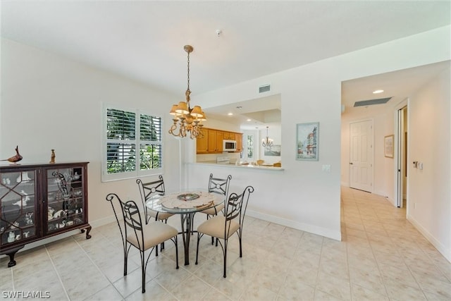 tiled dining room with an inviting chandelier