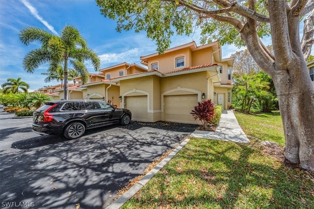 mediterranean / spanish-style home featuring a garage and a front yard