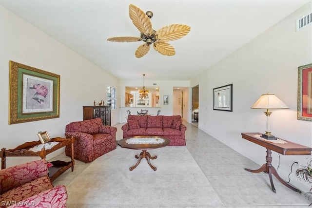 tiled living room with ceiling fan with notable chandelier