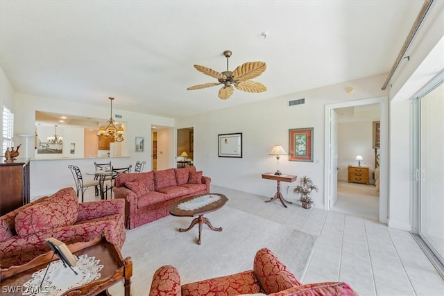 living room with ceiling fan with notable chandelier and light tile floors