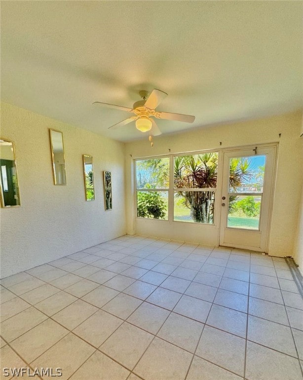 spare room featuring ceiling fan and light tile flooring