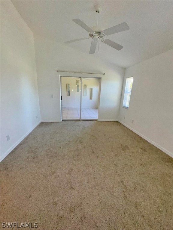 unfurnished bedroom featuring light carpet, ceiling fan, and vaulted ceiling