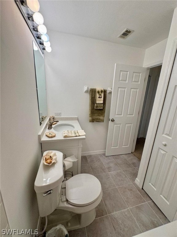 bathroom featuring vanity, toilet, and tile flooring