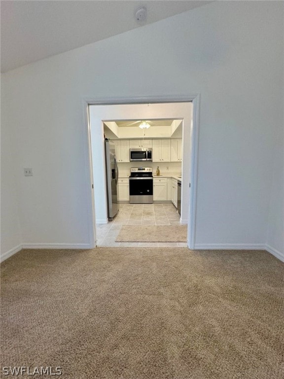 unfurnished living room with vaulted ceiling and light tile flooring