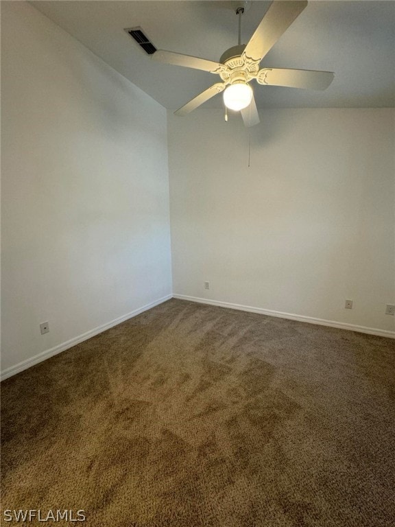 empty room with dark colored carpet, ceiling fan, and vaulted ceiling