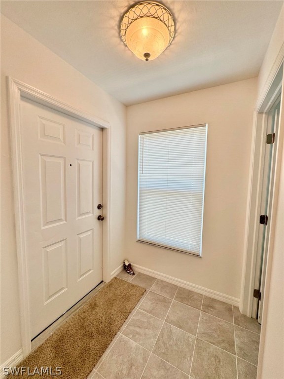 doorway to outside with light tile flooring