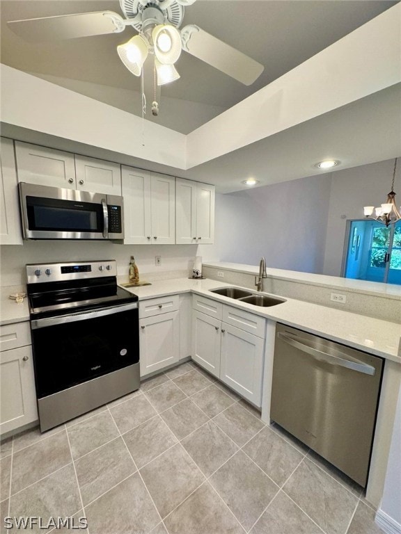 kitchen featuring white cabinetry, appliances with stainless steel finishes, light tile floors, sink, and ceiling fan