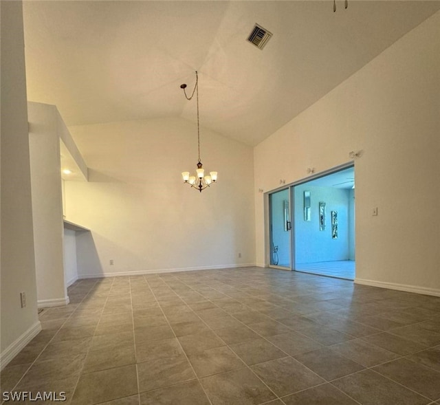 tiled empty room with high vaulted ceiling and an inviting chandelier