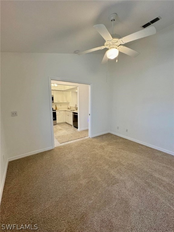 empty room with light colored carpet, ceiling fan, and lofted ceiling