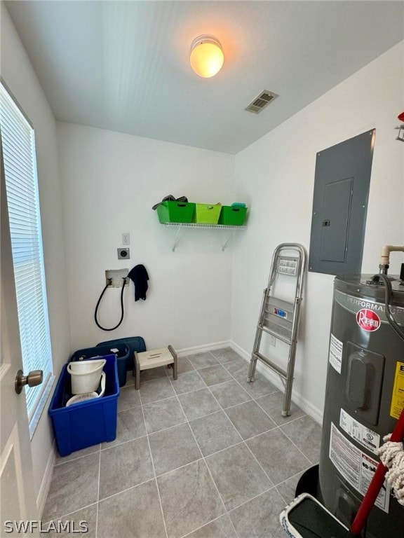 washroom featuring light tile floors and electric water heater