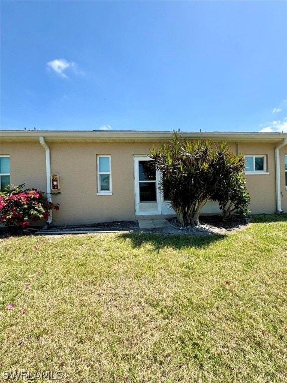 rear view of property featuring a yard