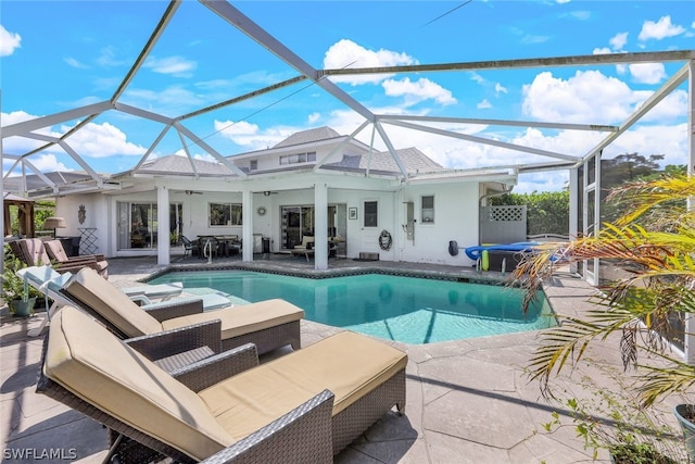 view of pool featuring an outdoor living space, ceiling fan, a patio area, and glass enclosure