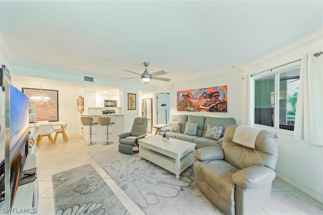 tiled living room featuring crown molding and ceiling fan with notable chandelier