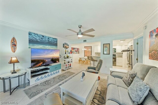 tiled living room with ceiling fan and ornamental molding