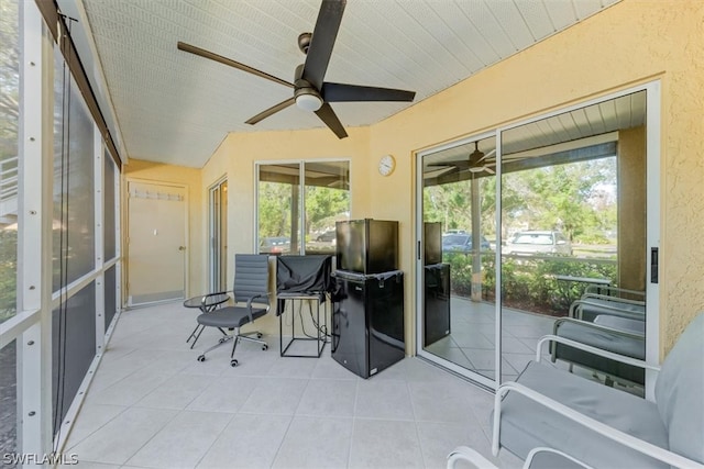 sunroom featuring ceiling fan and plenty of natural light