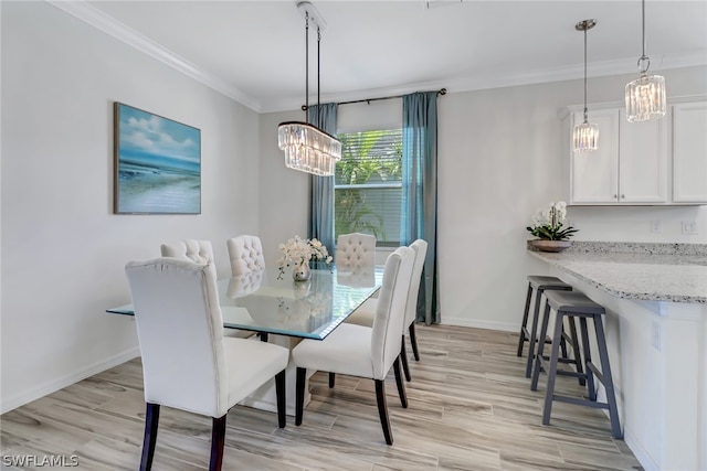 dining space featuring light hardwood / wood-style flooring, an inviting chandelier, and ornamental molding