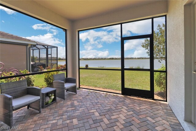 sunroom / solarium featuring a water view