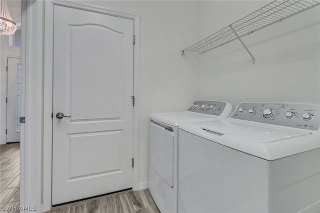 laundry room featuring light hardwood / wood-style flooring and washer and clothes dryer