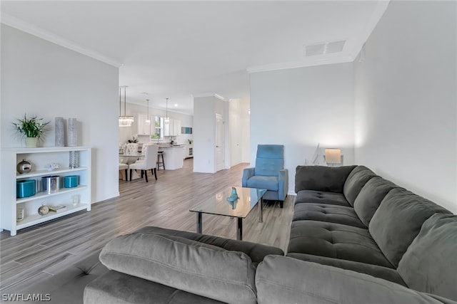 living room with crown molding and light hardwood / wood-style floors