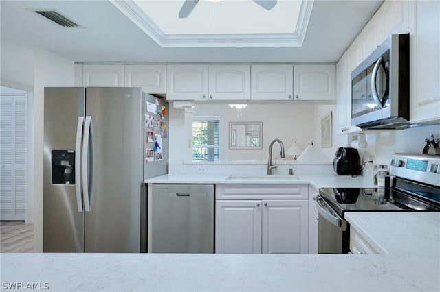 kitchen featuring appliances with stainless steel finishes, ceiling fan, white cabinetry, and sink