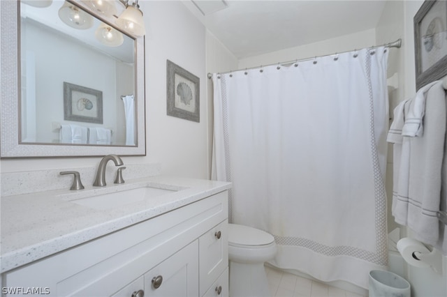 bathroom featuring tile floors, vanity, and toilet