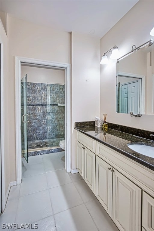 bathroom with walk in shower, tile patterned floors, vanity, and toilet