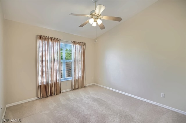 spare room featuring lofted ceiling, light colored carpet, and ceiling fan