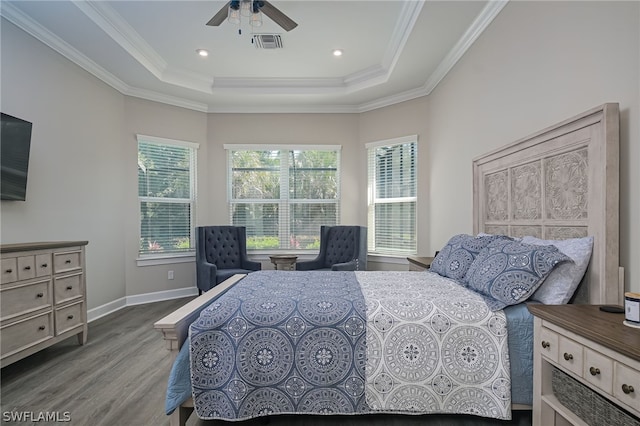 bedroom featuring a tray ceiling, hardwood / wood-style flooring, ornamental molding, and ceiling fan