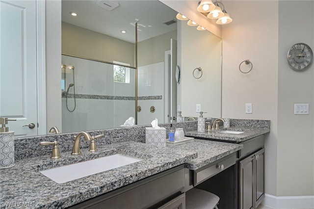 bathroom with a tile shower and vanity