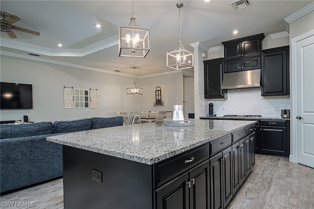 kitchen featuring tasteful backsplash, crown molding, a kitchen island, and pendant lighting