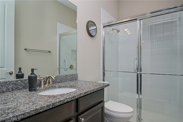 bathroom with walk in shower, vanity, and toilet