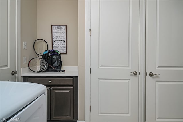 washroom with cabinets and washing machine and clothes dryer