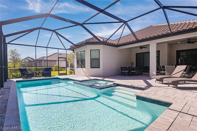 view of swimming pool featuring an in ground hot tub, a patio, ceiling fan, and glass enclosure