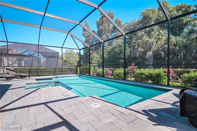 view of swimming pool featuring a patio area and glass enclosure