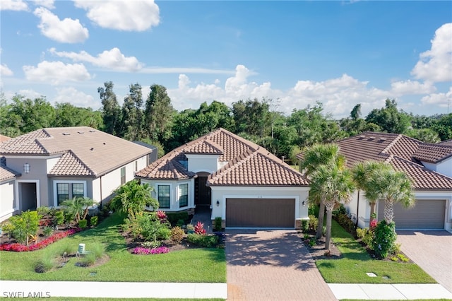 mediterranean / spanish-style home with a garage and a front lawn