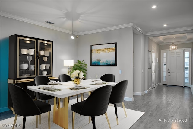 dining area featuring hardwood / wood-style floors and crown molding