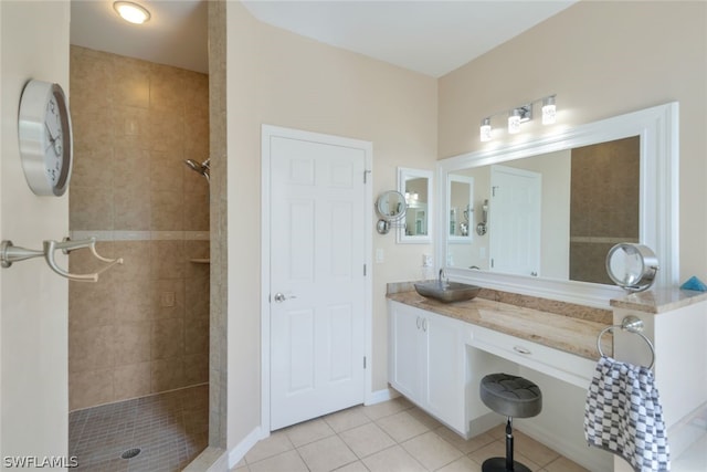 bathroom featuring vanity, tiled shower, and tile flooring