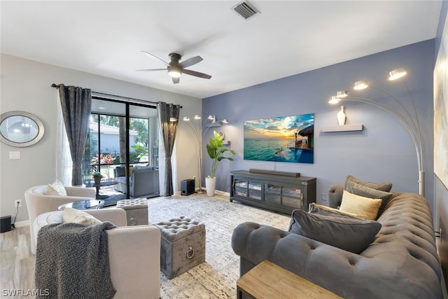 living room featuring ceiling fan and hardwood / wood-style flooring