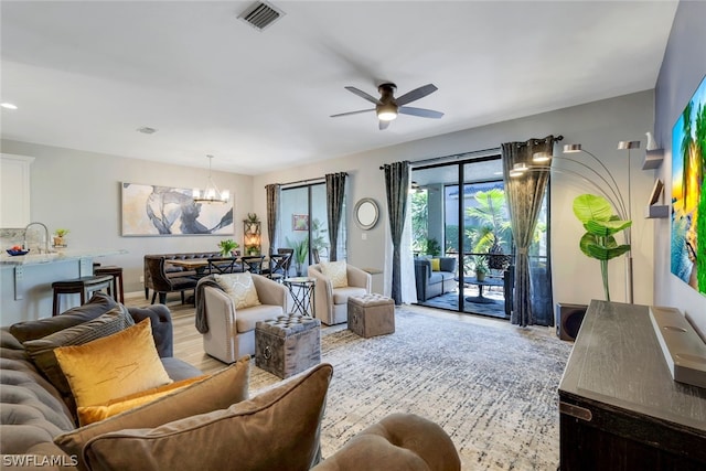 living room featuring sink, ceiling fan with notable chandelier, and hardwood / wood-style flooring